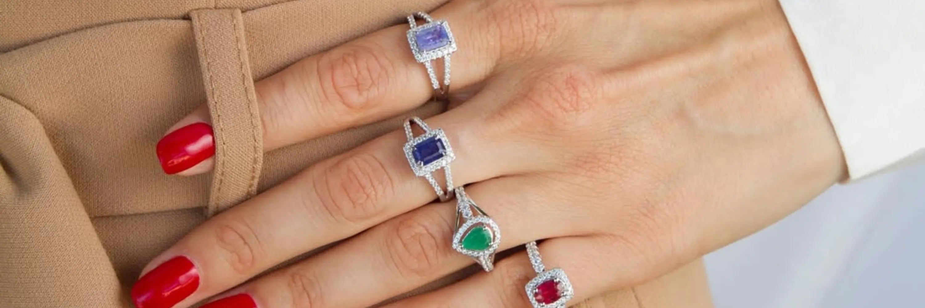 A woman wearing four gemstone rings in different colors