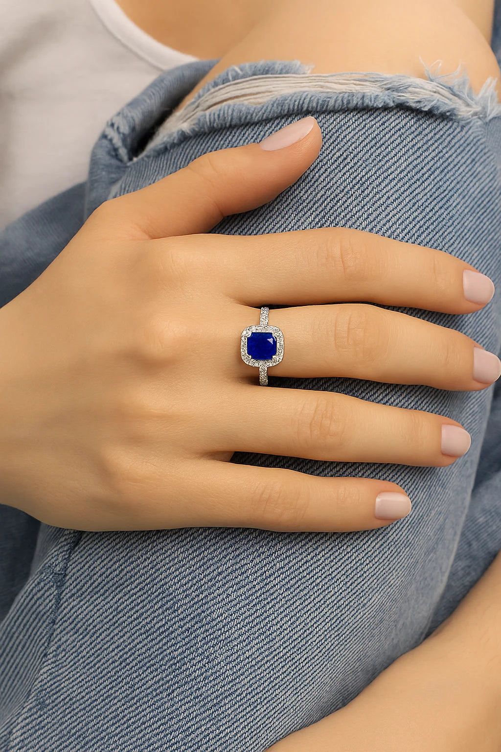 Model wearing Cavell Touch of Luxury natural sapphire ring in sterling silver surrounded by round-cut cubic zirconia accents