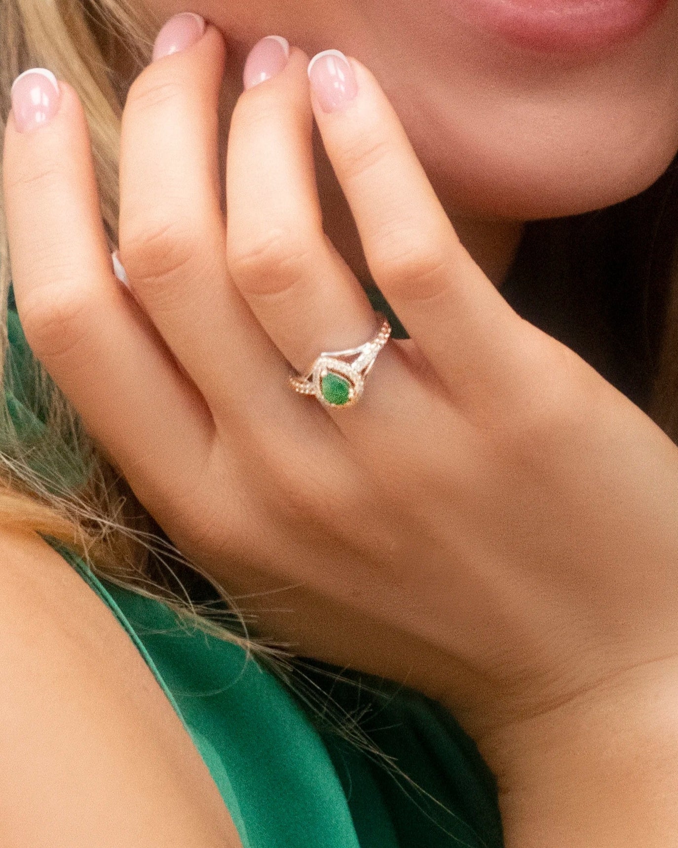 Model wearing Cavell Tear Drop of Joy natural emerald ring in sterling silver surrounded by round-cut cubic zirconia accents