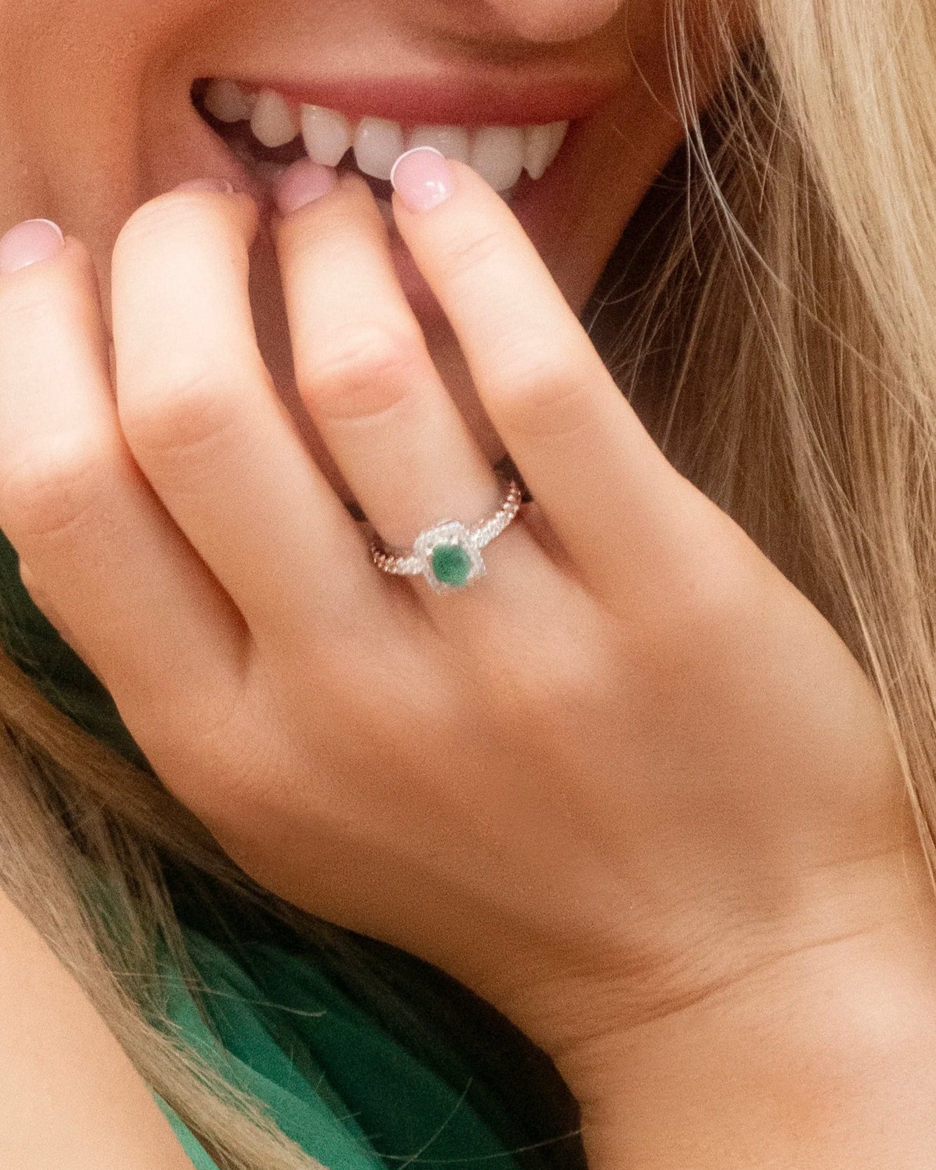 Model wearing Cavell Everlasting Devotion natural emerald ring in sterling silver surrounded by round-cut cubic zirconia accents