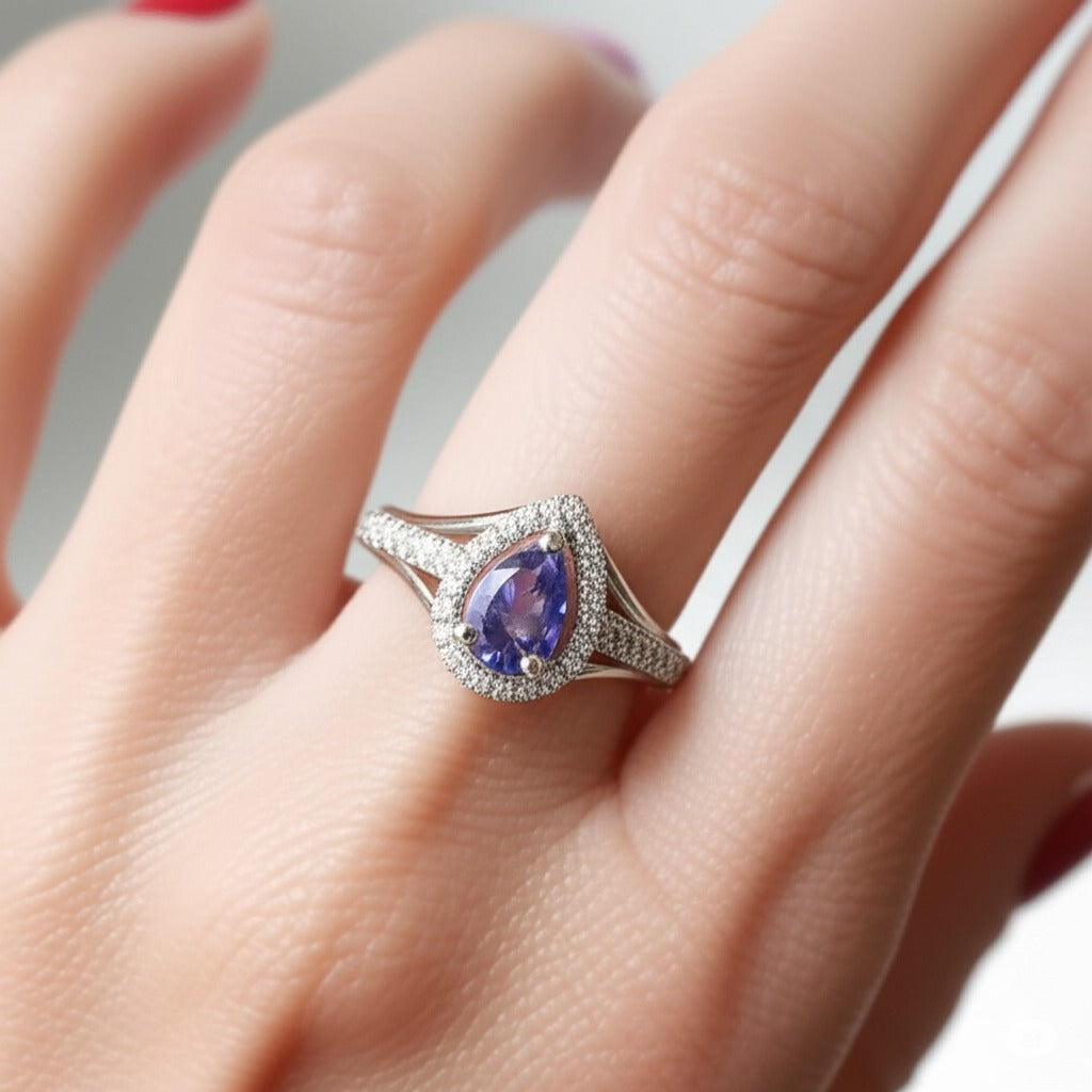 Model wearing Cavell Tear Drop of Joy natural tanzanite ring in sterling silver surrounded by round-cut cubic zirconia accents
