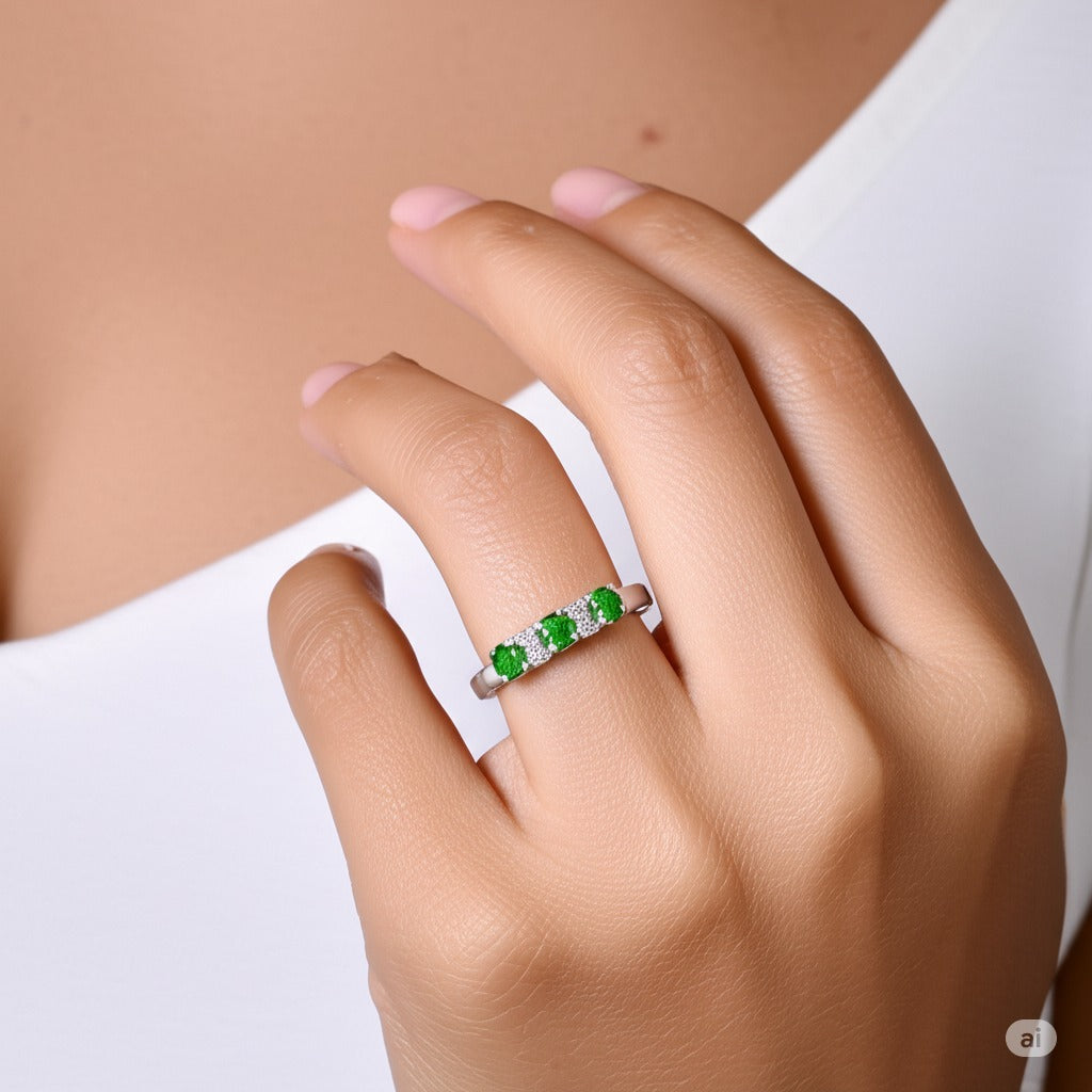 Model wearing Cavell Trilogy of Loyalty natural emerald ring in sterling silver surrounded by round-cut cubic zirconia accents