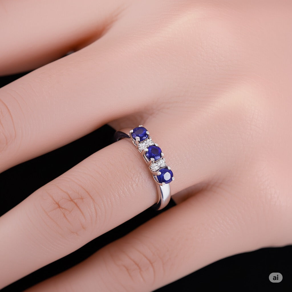 Model wearing Cavell Trilogy of Loyalty natural sapphire ring in sterling silver surrounded by round-cut cubic zirconia accents