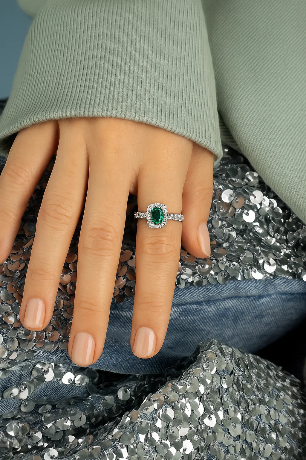 Model wearing Cavell Feel Timeless natural emerald ring in sterling silver surrounded by round-cut cubic zirconia accents