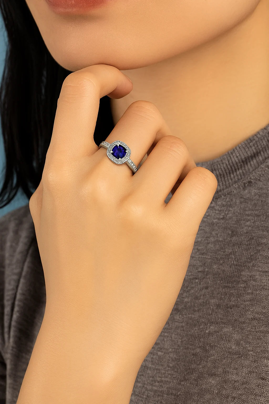 Model wearing Cavell Everlasting Devotion natural sapphire ring in sterling silver surrounded by round-cut cubic zirconia accents