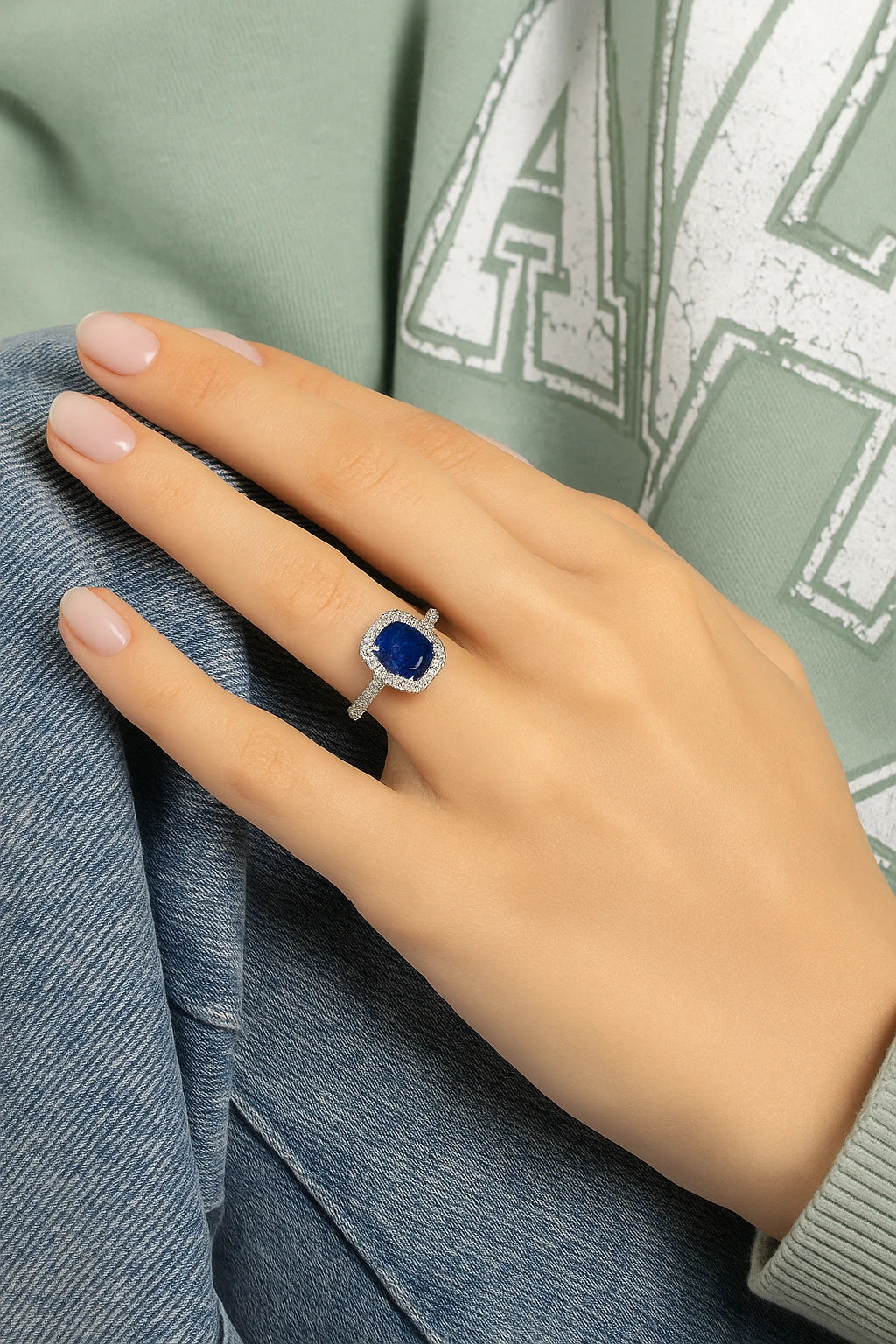 Model wearing Cavell Feel Timeless natural sapphire ring in sterling silver surrounded by round-cut cubic zirconia accents