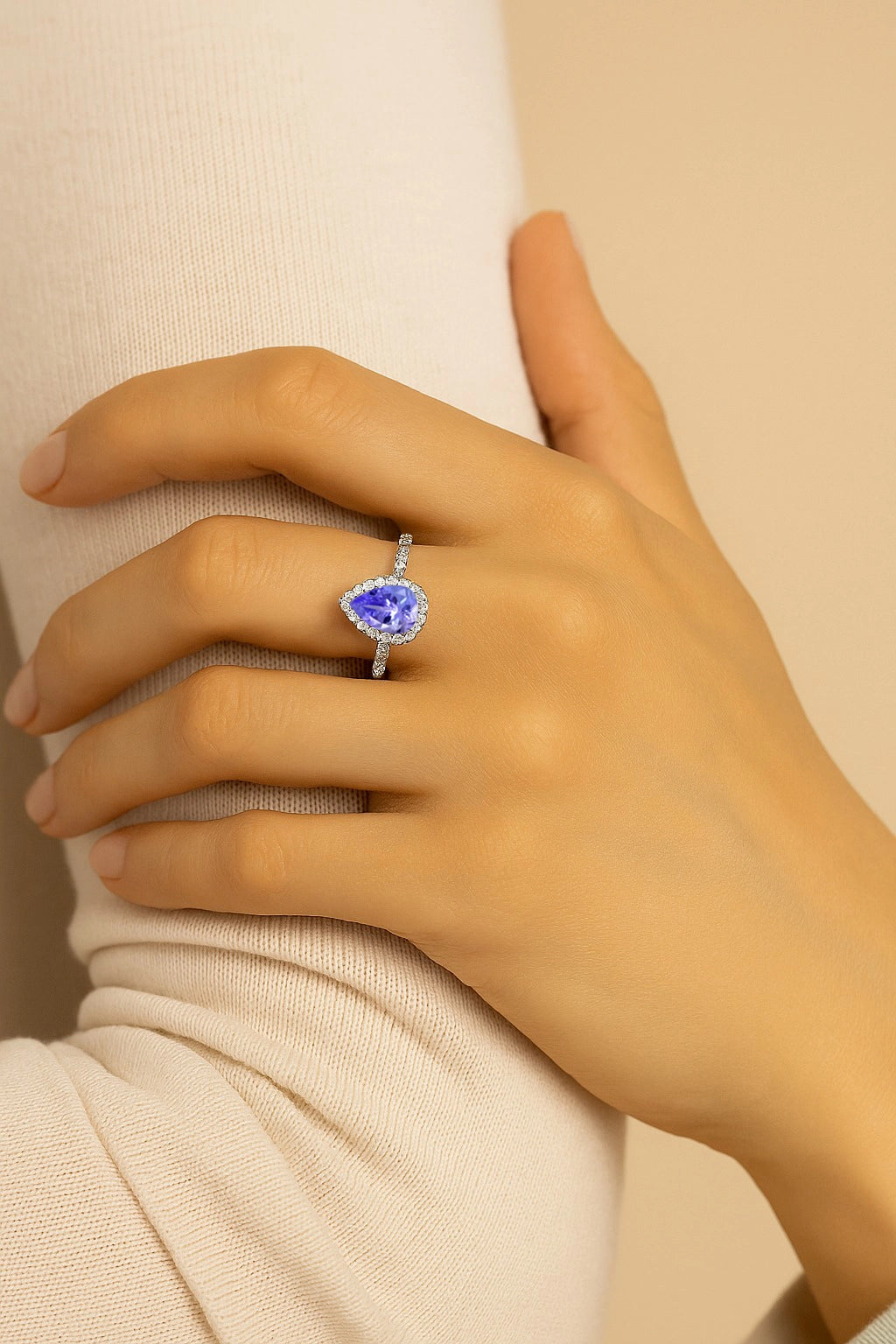 Model wearing Cavell Drop of Passion natural tanzanite ring in sterling silver surrounded by round-cut cubic zirconia accents