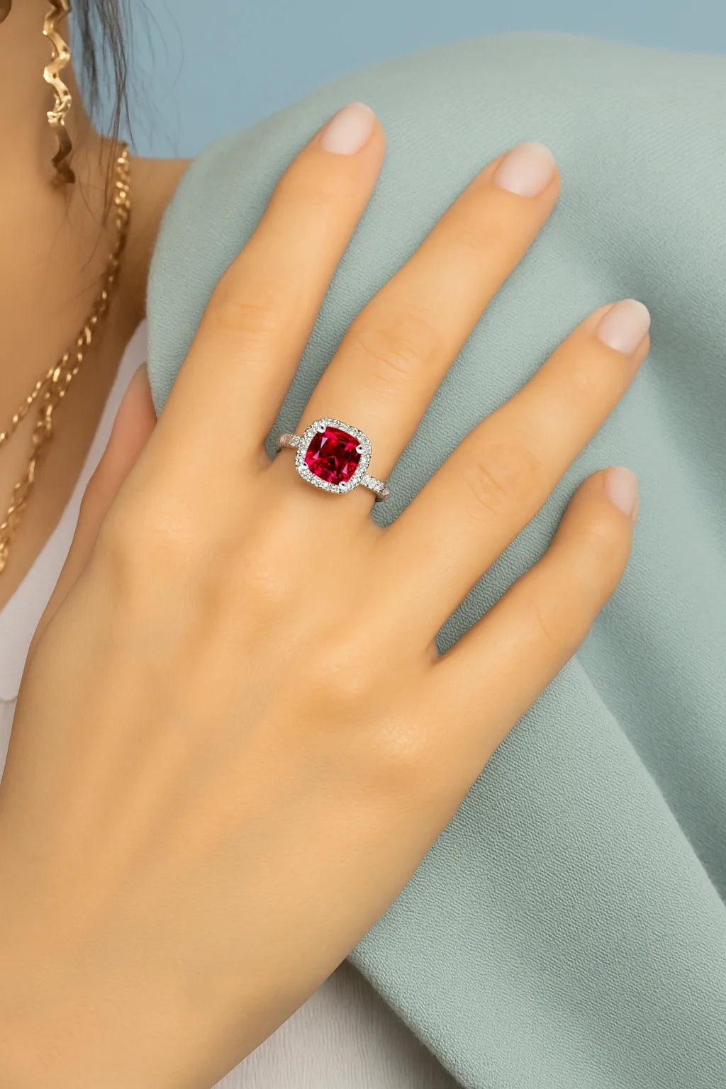Model wearing Cavell Touch of Luxury natural ruby ring in sterling silver surrounded by round-cut cubic zirconia accents