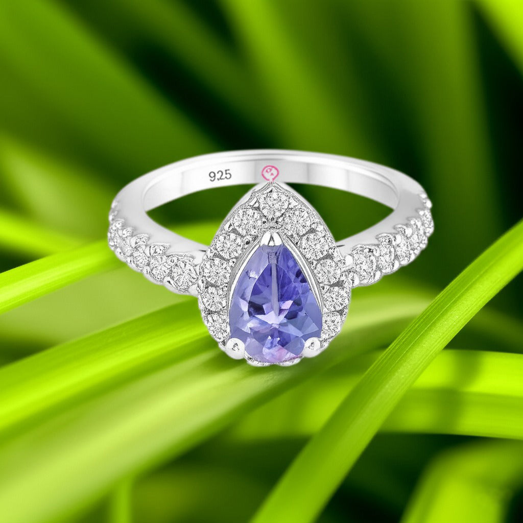 Cavell Drop of Passion natural tanzanite ring in sterling silver surrounded by round-cut cubic zirconia accents placed on a surface