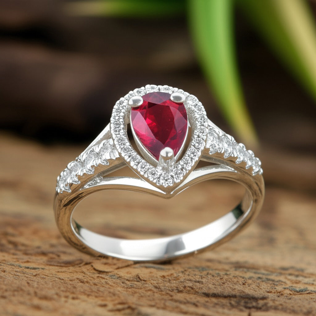 Angled view of Cavell Tear Drop of Joy natural ruby ring in sterling silver surrounded by round-cut cubic zirconia accents
