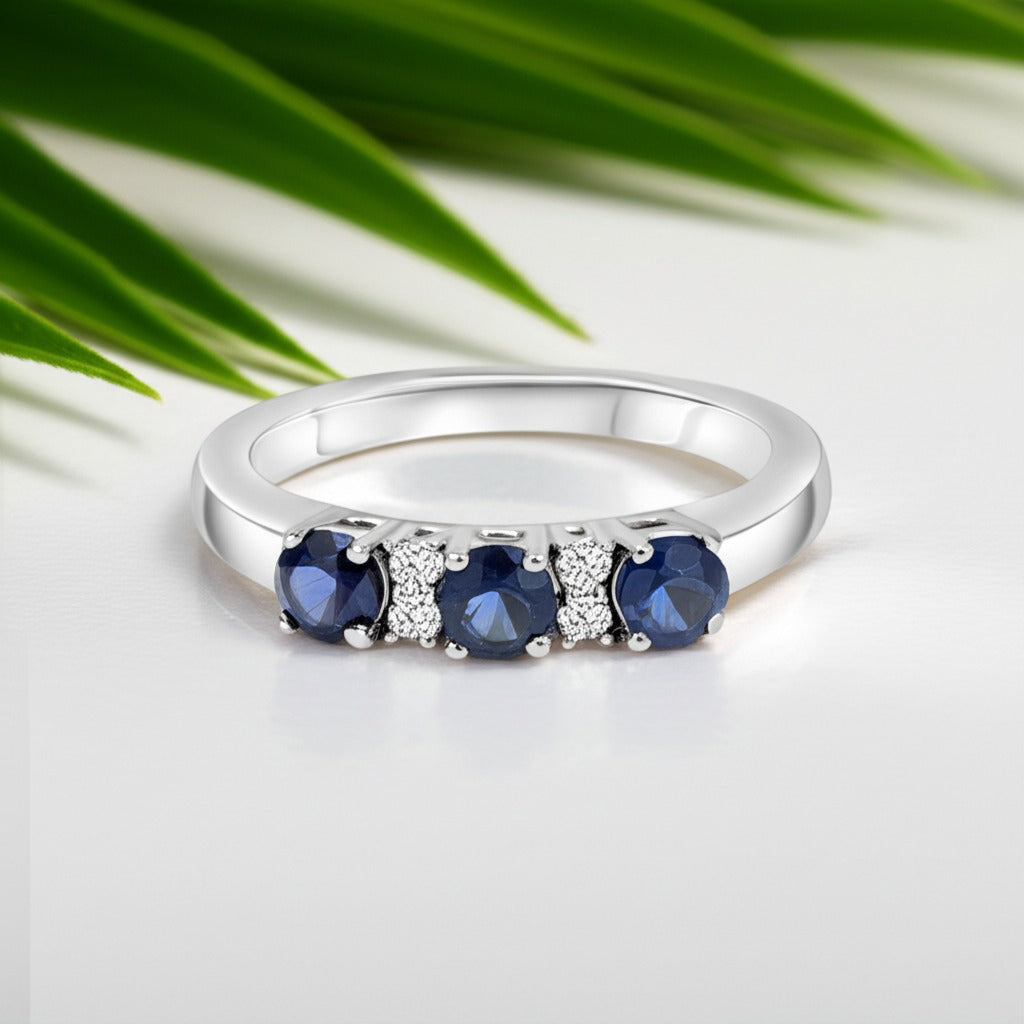 Cavell Trilogy of Loyalty natural sapphire ring in sterling silver surrounded by round-cut cubic zirconia accents placed on a surface