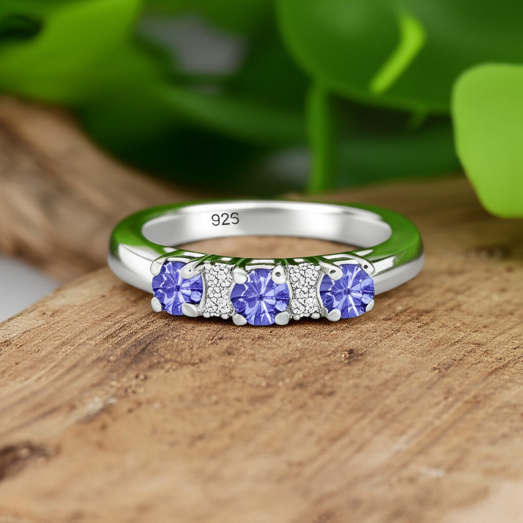 Cavell Trilogy of Loyalty natural tanzanite ring in sterling silver surrounded by round-cut cubic zirconia accents placed on a surface